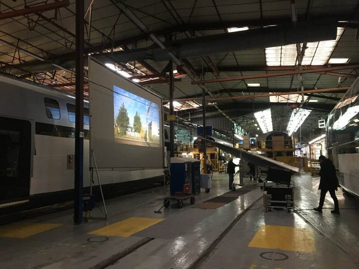 Serre moi fort — wagon dans l'usine Alstom, paysage projeté derrière les fenêtres